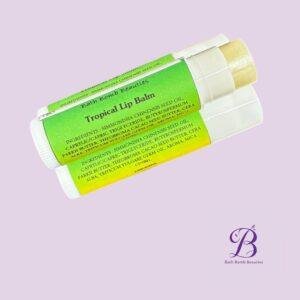 Tropical lip balm bath bomb beauties Two green labeled tropical lip balm tubes placed diagonally on a lavender background with bath bomb beauties logo in the bottom right