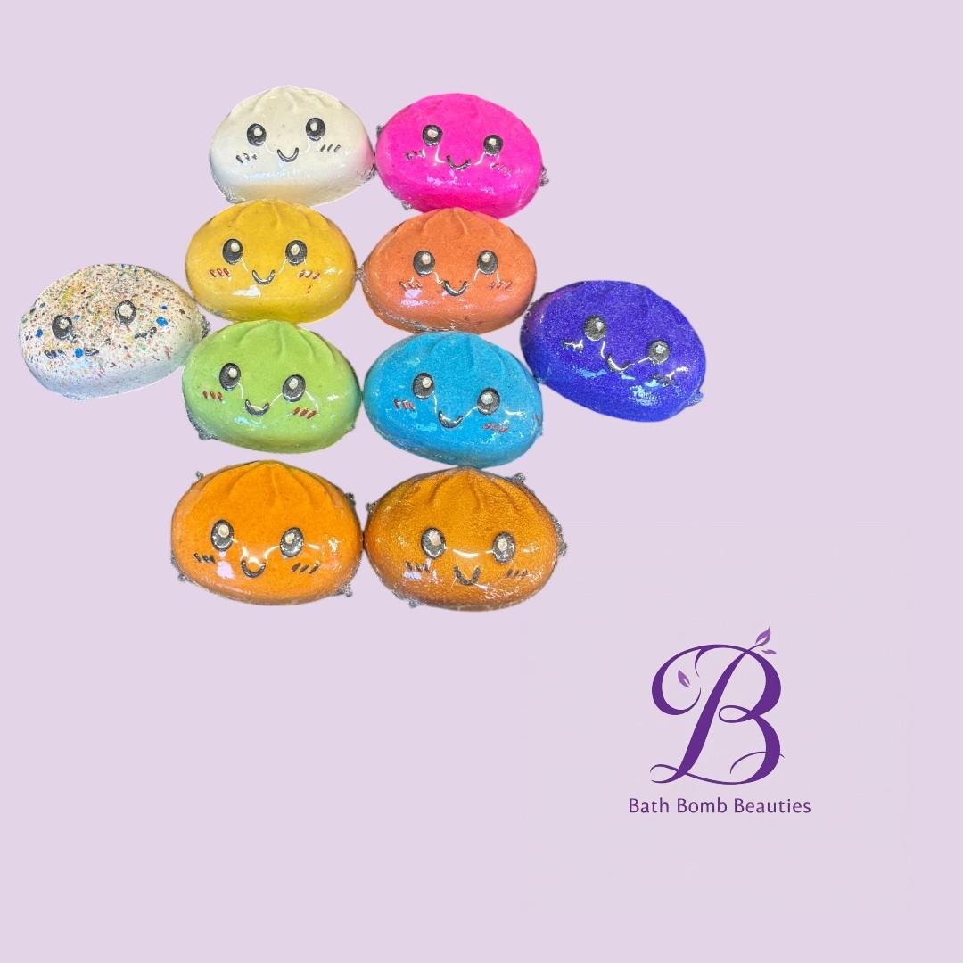 Squishy dumplings bath bomb beauties Colorful smiley bath bombs arranged in a pyramid on a lavender background with a bath bomb beauties logo in the corner