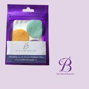 Purple resealable pouch containing three colorful bath discs orange mint green purple with bath bomb beauties label on a pastel background