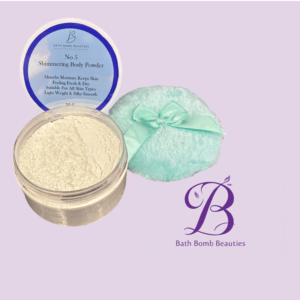 Container of no  shimmering body powder with blue lid label atop a lavender backdrop alongside a mint satin pouch and bath bomb beauties logo
