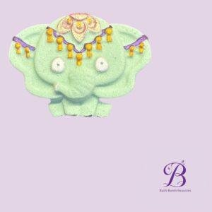 Mint green decorative bust with purple and gold tassel garlands against a lavender background bath bomb beauties logo visible in the bottom right corner