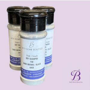 Three bottles of Bath Bomb Beauties Pink Clouds Dry Shampoo for dark brown/black hair, set against a lavender background with the Bath Bomb Beauties logo in the bottom right.