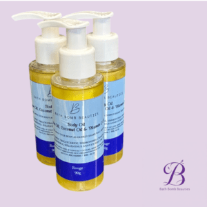 Three bottles of bath bomb beauties body oil on a lavender backdrop with blue labels and a corner logo